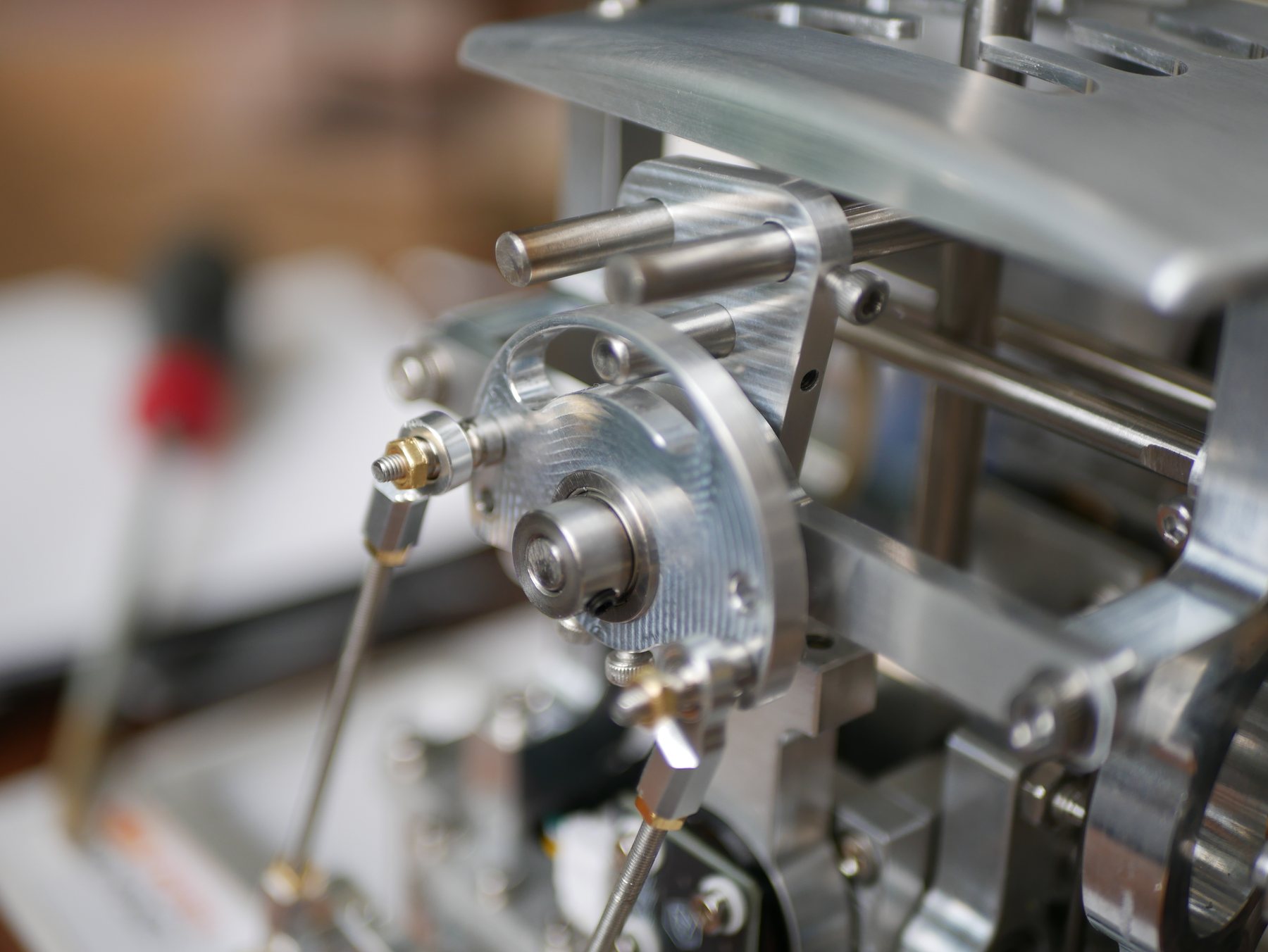 Close-up of the auto-sync mechanism: angular sensor disc, brass-fitted linkage, and shift output shaft.